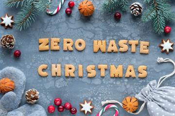 Text Zero Waste Christmas made from cookies. Xmas flat lay with fir twigs, textile gift bag,...