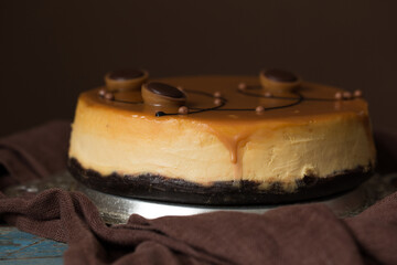 Cheesecake with salted caramel on brown  background. Copy space for text.