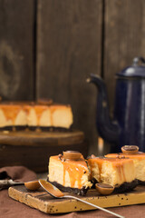 Cheesecake with salted caramel on brown  background. Copy space for text.