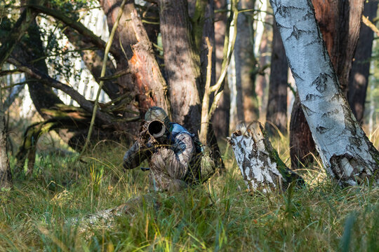 Zamaskowany człowiek fotograf w lesie