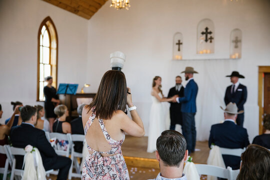 Female photographer with camera working church wedding