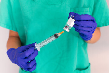 two hands, of a young nurse, holding a vaccine sample