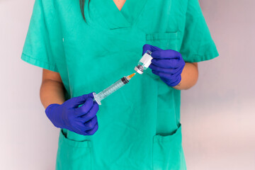 two hands, of a young nurse, holding a vaccine sample