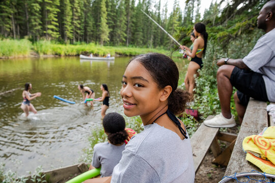 Girl watching friends having fun in river