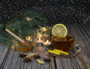 Obraz na płótnie Canvas Fragrant tea with honey lemon and ginger, candles and star anise