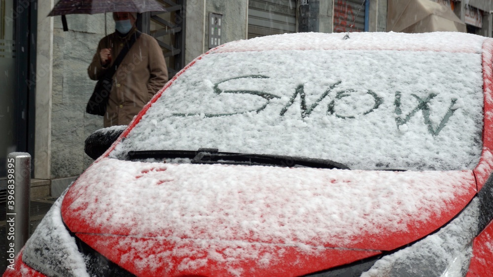 Wall mural Europe, Italy , Milan December 2020 - snow time in the city during Covid-19 Coronavirus lockdown - red car with the written 