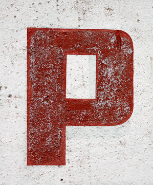 The letter P is red on a worn white background. Grunge texture of old paint in cracks and wear