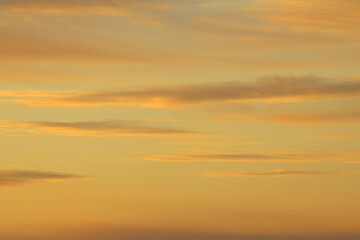 Sun below the horizon and clouds in the fiery dramatic orange sky at sunset or dawn backlit by the sun. Place for text and design.