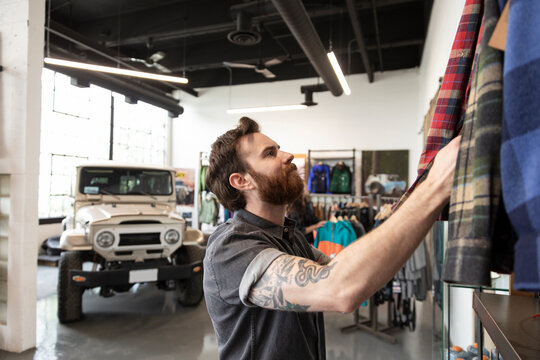 Man With Tattoos And Beard Shopping In Sporting Goods Store