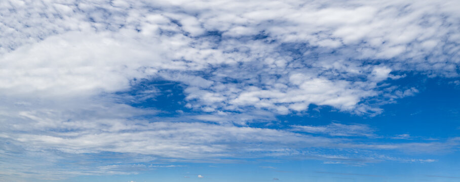 Blue sky with clouds in sunlight, wide cloudscape background panorama © wildman