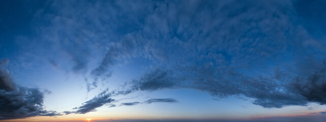 Fluffy clouds in evening sunset sky panoramic view. Climate, environment and weather concept cloudscape background.