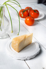 piece of cheese with tomatoes on a wooden board, cheese samples, cheese with a cut on a white background