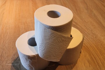 Rolls of toilet paper on a wooden underground. A hamster purchases concept during COVID-19