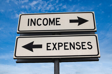 Income versus expenses road sign. White two street signs with arrow on metal pole with word. Directional road. Crossroads Road Sign, Two Arrow. Blue sky background. Two way road sign with text.