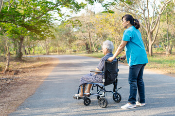 Doctor help and care Asian senior or elderly old lady woman patient sitting on wheelchair at park in nursing hospital ward, healthy strong medical concept.