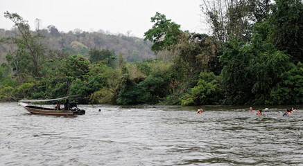 Fototapeta na wymiar Tourists float in lifejackets on the river Kwai