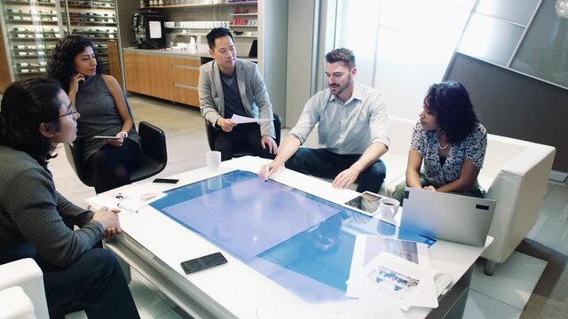 Colleagues brainstorming at smart touchscreen table