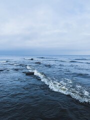 Sea view with small waves and cloudy gray sky