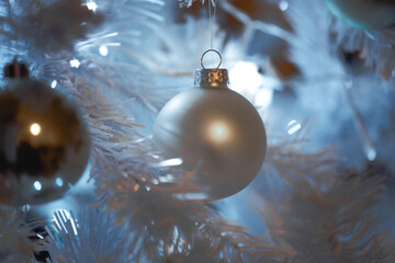 White christmas ball hanging on christmas tree, blue and soft mood