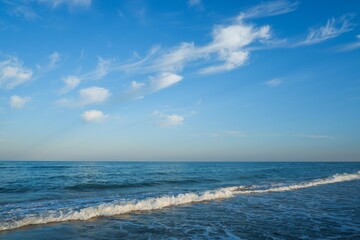 Fototapeta na wymiar Sea beach with blue sky and yellow sand and some clouds