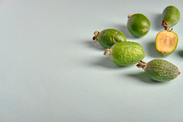 Green feijoa on a blue background, side view