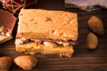 Almond nougat, typical Christmas dessert on wooden background