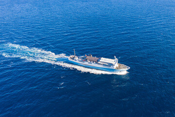 Aerial drone view of a passenger ship, blue sea background.
