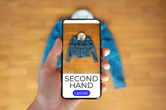 View of a person taking a photo of a jacket to upload in a second hand clothes app
