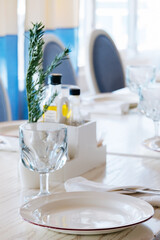 blurred background  elegant table setting with white plate and crystal glass