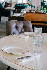 blurred background  elegant table setting with white plate and crystal glass