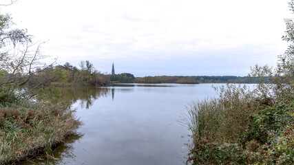 The De Poel lake in Amstelveen with the Sint-Urbanuskerk church tower on the horizon.