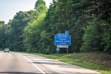 Highway road interstate 95 in North Carolina with blue sign and text for Virginia Welcome Center...