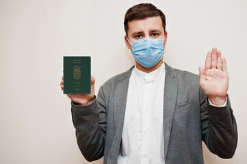 European man in formal wear and face mask, show Faroe Islands passport with stop sign hand. Coronavirus lockdown in Europe country concept.