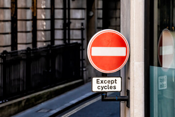 London, UK downtown city road street with urban traffic red no entry stop sign except cycles bicycles with nobody