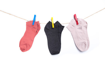 several colored socks hanging on a rope with clothespins isolated on white background
