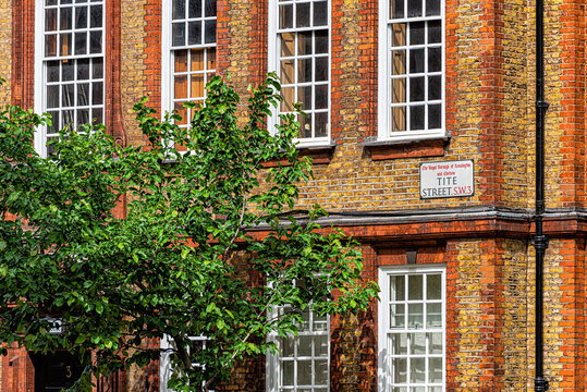 Victorian style red brick terraced architecture apartment flat building in royal borough of Chelsea and Kensington with windows in London, United Kingdom