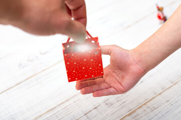 Gift giving. Bright little gift in hand.