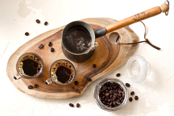 Finjan coffee pot and two espresso cups on a wooden stand, top view