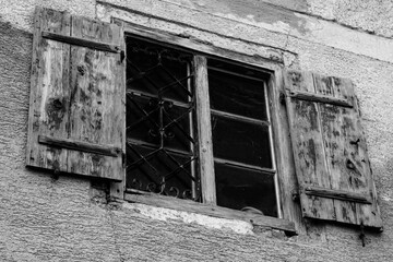 Altes Fenster mit Gitter in schwarz weiß