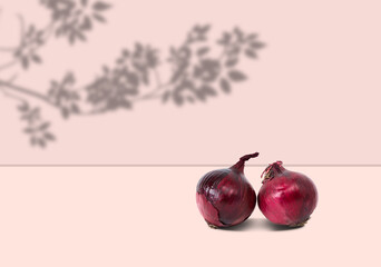 Red onion on a pink background. The concept of eating food with onions.