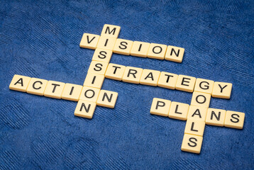 vision, mission, goals, strategy, plan  and action crossword in ivory letter tiles against textured...