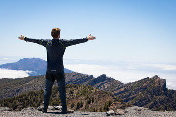 happy man above the clouds travelling on Canary Island La Palma