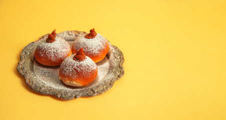 Hanukkah donuts on a vintage plate on yellow background