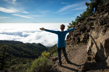 happy man above the clouds travelling on Canary Island La Palma