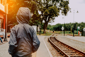 The boy at the train station. Little boy looking for a train, travel concept.