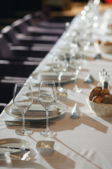 Serving the festive table in the restaurant. Christmas table with glasses, plates, fork, knife. Bread, butter and snacks on the New Year's table. Dinner in an expensive restaurant with wine