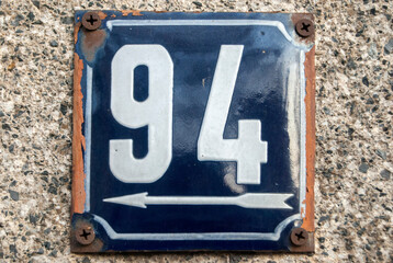 Weathered grunge square metal enameled plate of number of street address with number 94