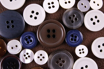 Set of different buttons on brown leather background
