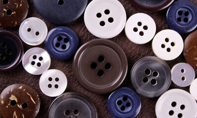 Set of different buttons on brown leather background