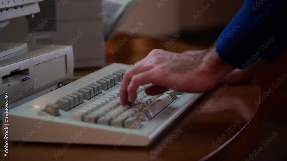 Poster close-up of man typing on old computer. media. man is typing on old keyboard with computer. retro co